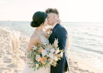 wedding couple on beach kissing