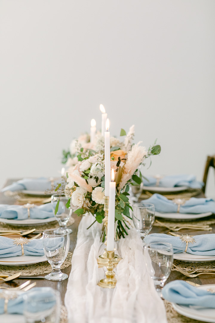 table setting with blue napkins at south haven creations wedding venue