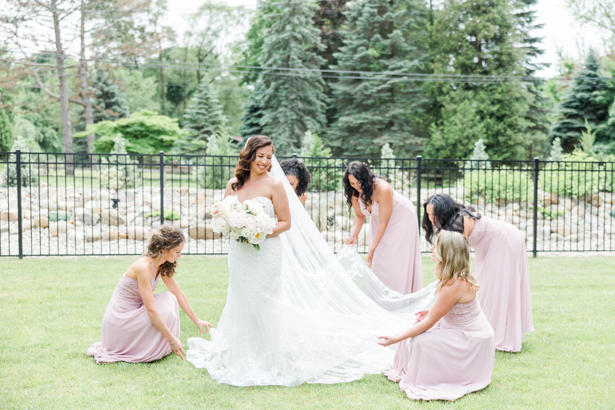 bridal party fixing dress on front lawn