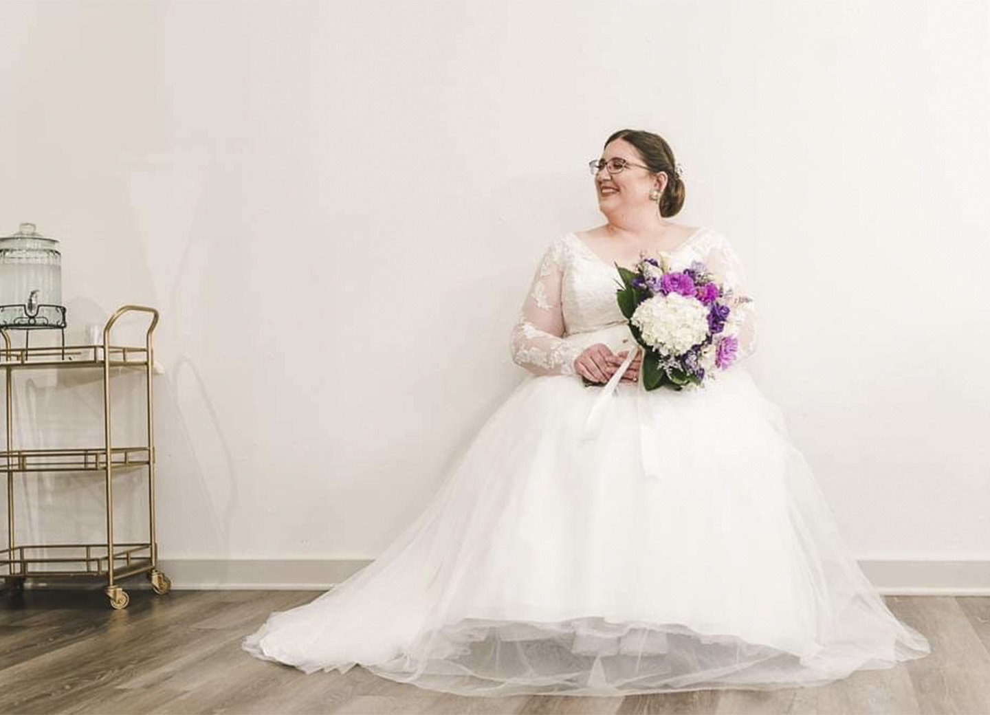 Bride sitting in chair with flowers in the bridal suite.