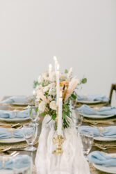 table setting with blue napkins at south haven creations wedding venue