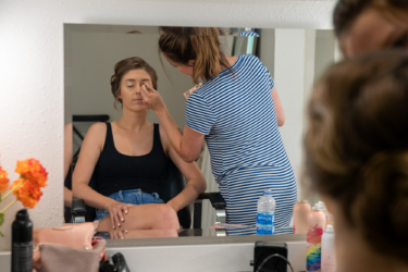 bridal suite with lady applying makeup to bride