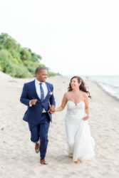 bride and groom running on the beach