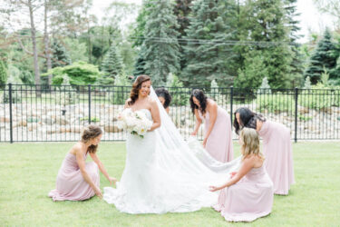 bridal party fixing dress on front lawn