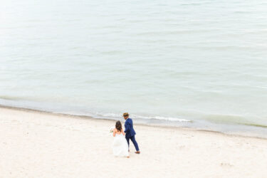 bride and groom walking on the lakeshore
