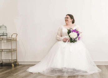 bride in the bridal suite sittin on chair with flowers